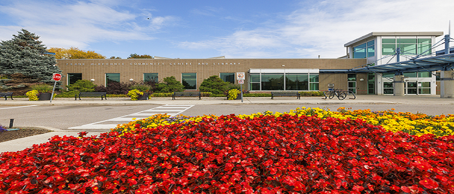 A wide view shot of a building with red flowers in front